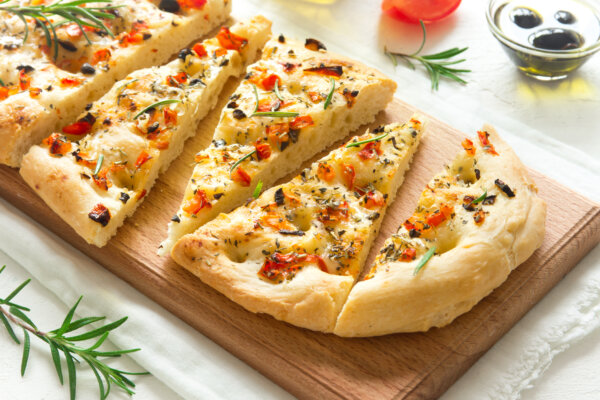 Seasoned focaccia sliced on a cutting board