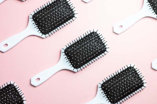 Hair brushes on a pink background