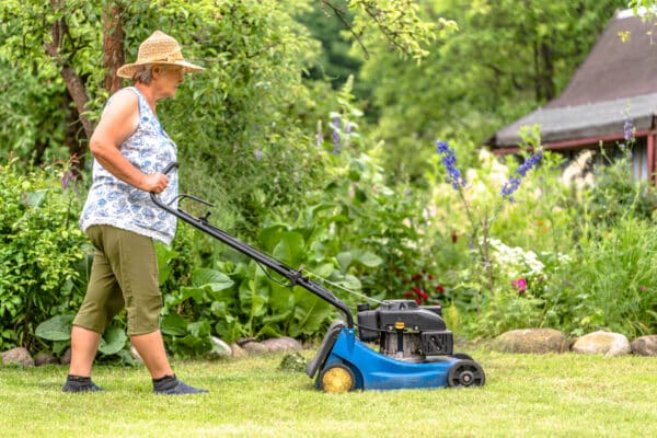 Older woman mowing the lawn